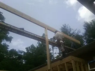 Carpenter setting a ridge beam over a new addition frame — Ice Dam Removal by Roofing Brothers in Virginia City