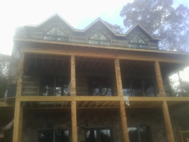 Dormers and porch framing on a large log home under construction — Roof Coating work by our crew in Virginia City
