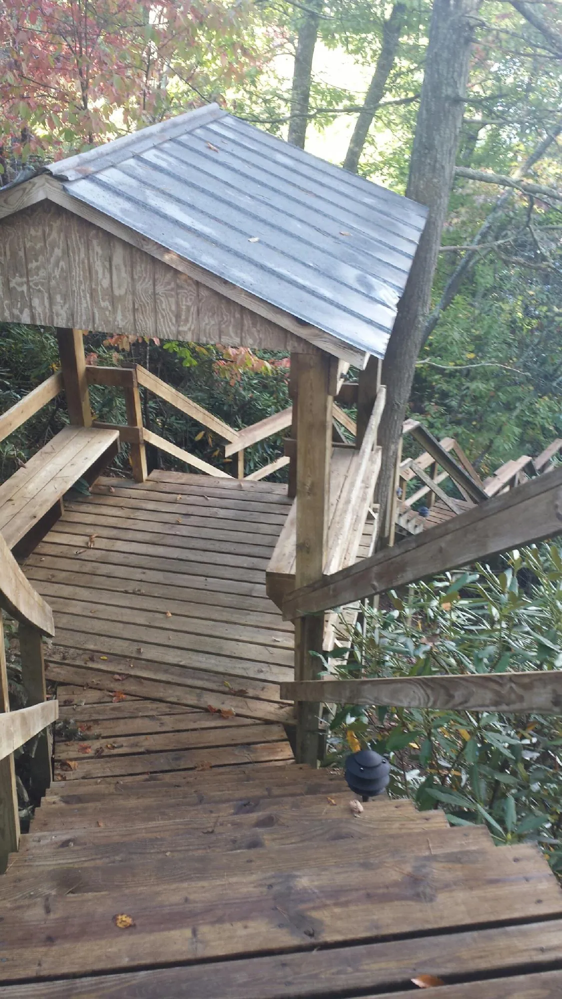 Metal roofed shelter over wooden steps on a wooded walkway — Skylight Repair & Installation work by our crew in Virginia City