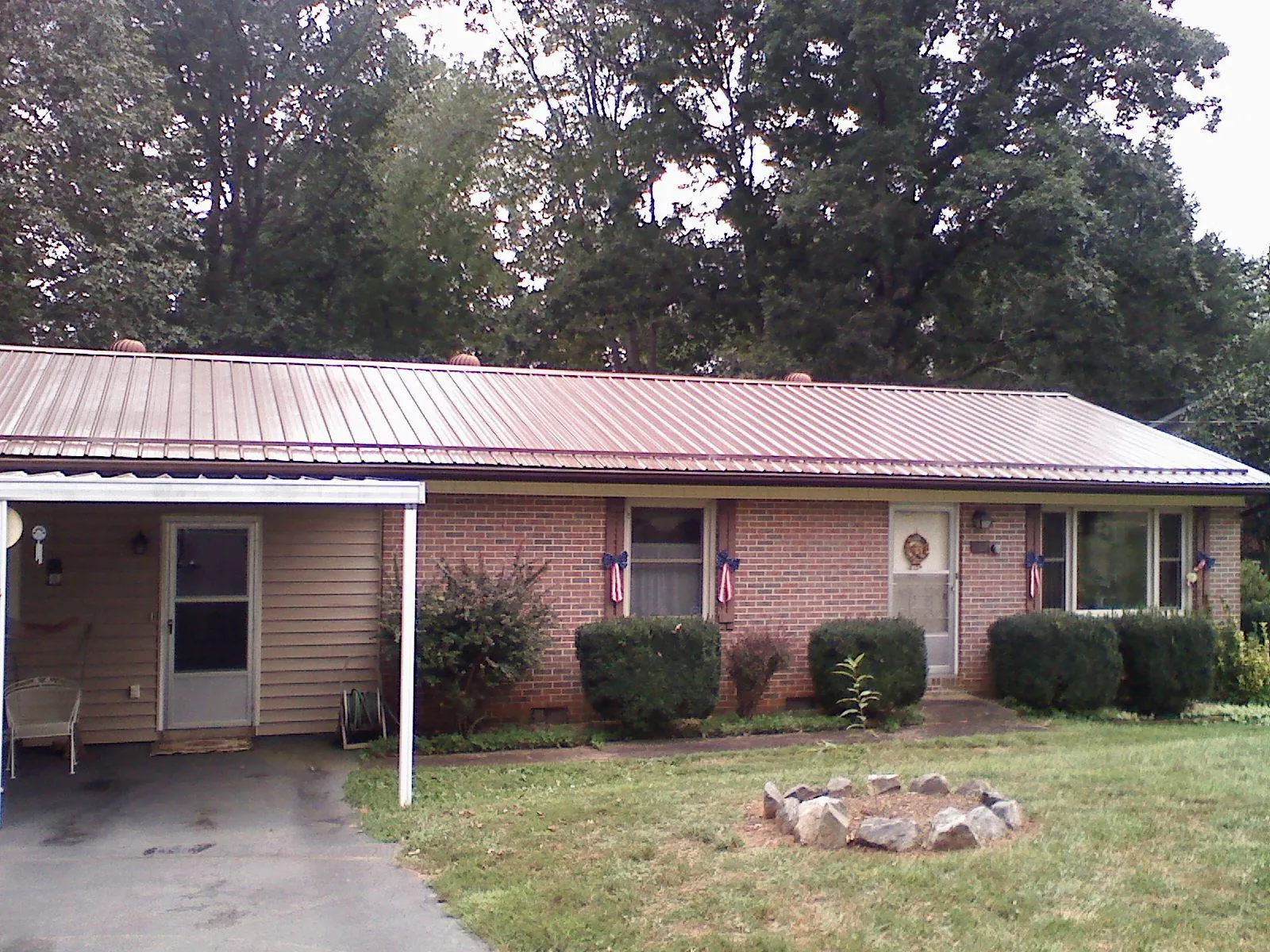 Bronze metal roof and carport on a brick ranch home — Roof Repair work by our crew in Virginia City